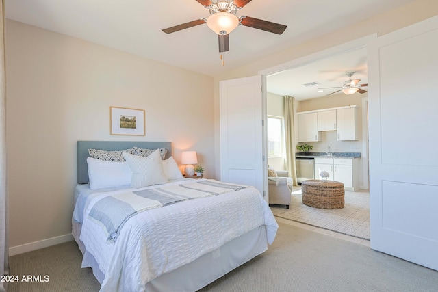 bedroom with ceiling fan, sink, and light colored carpet