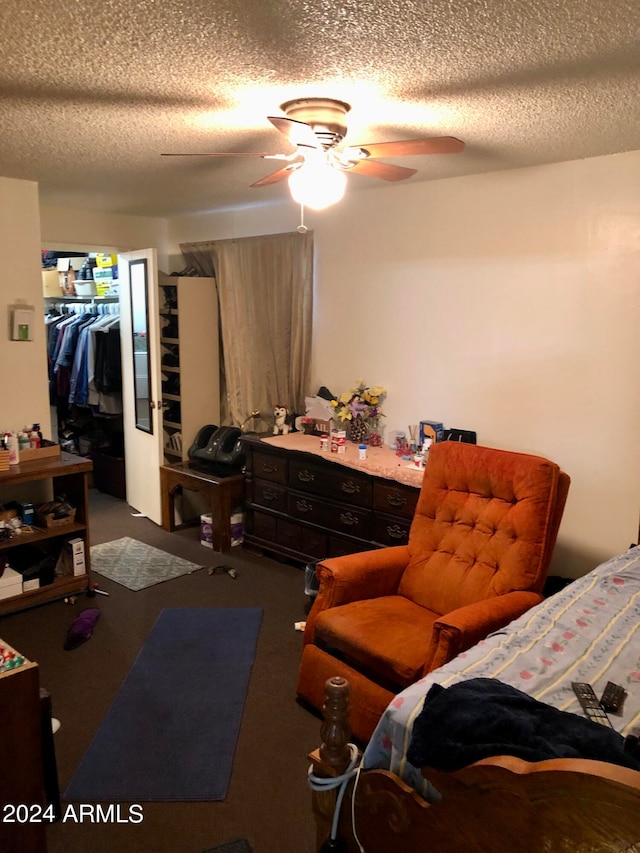 carpeted bedroom with a textured ceiling, a closet, and ceiling fan