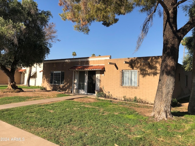 pueblo revival-style home featuring a front yard