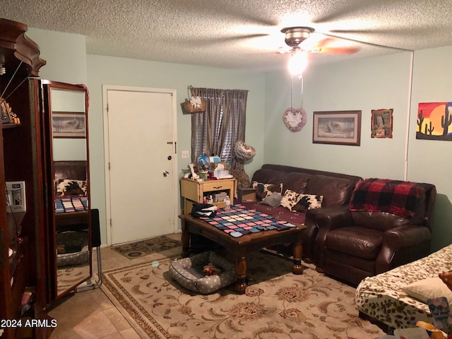 tiled living room with ceiling fan and a textured ceiling