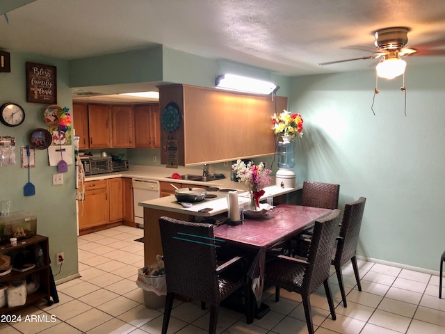 dining area with light tile patterned flooring, sink, and ceiling fan