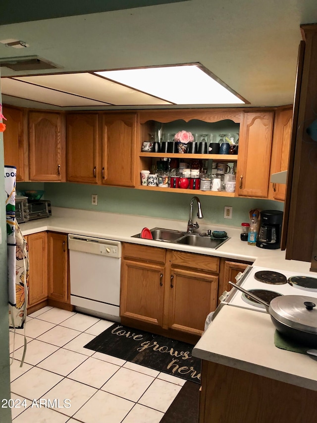 kitchen featuring sink, white dishwasher, and light tile patterned floors