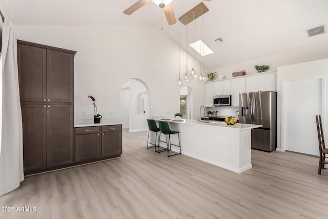 12529 N 83rd Ln, Peoria, AZ 85381 - kitchen with stainless steel appliances, arched walkways, a ceiling fan, light wood-style floors, and a sink