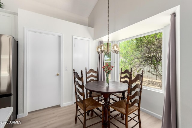12529 N 83rd Ln, Peoria, AZ 85381 - dining area with a chandelier, light wood-style flooring, vaulted ceiling, and baseboards