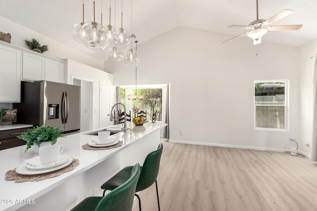 12529 N 83rd Ln, Peoria, AZ 85381 - kitchen with stainless steel fridge, a sink, a chandelier, light countertops, and high vaulted ceiling