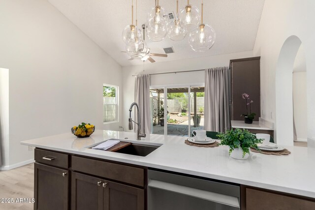 12529 N 83rd Ln, Peoria, AZ 85381 - kitchen featuring a sink, dishwasher, arched walkways, light countertops, and vaulted ceiling