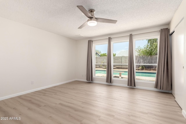12529 N 83rd Ln, Peoria, AZ 85381 - spare room featuring light wood finished floors, healthy amount of natural light, a textured ceiling, a ceiling fan, and baseboards