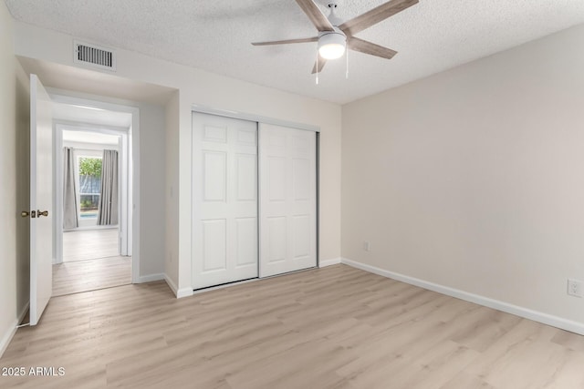 12529 N 83rd Ln, Peoria, AZ 85381 - unfurnished bedroom with light wood-style flooring, a textured ceiling, baseboards, a closet, and ceiling fan