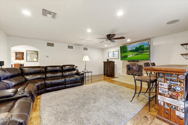 living room featuring light hardwood / wood-style flooring and ceiling fan