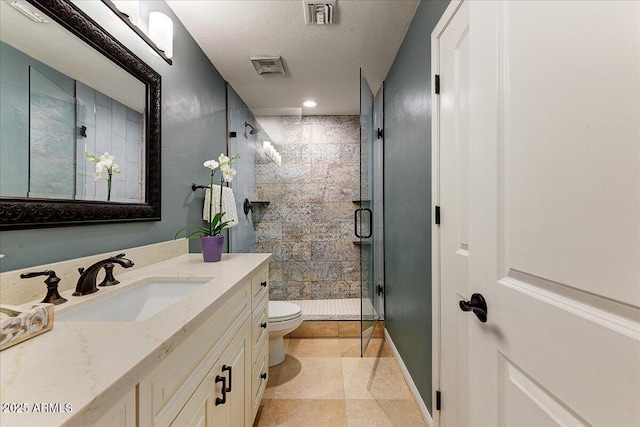 bathroom featuring vanity, a shower with shower door, a textured ceiling, and toilet