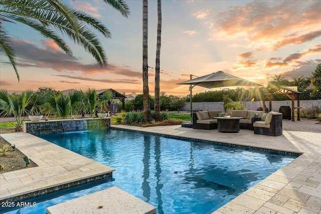 pool at dusk with an outdoor hangout area and a patio area