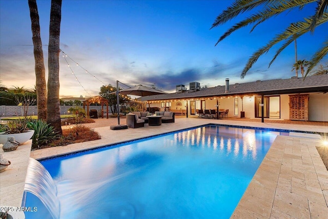 pool at dusk with an outdoor hangout area, central AC, and a patio area