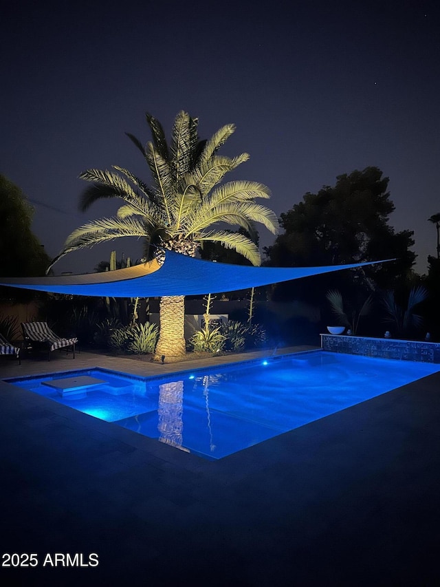 view of pool at twilight