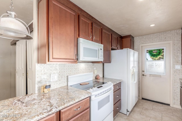 kitchen featuring light stone counters, white appliances, and light tile patterned floors