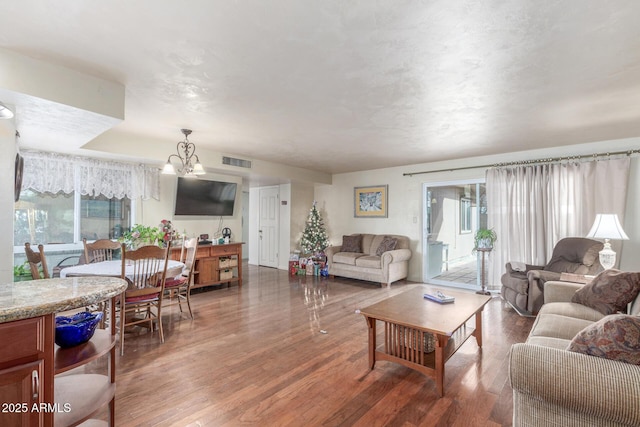 living room with hardwood / wood-style floors and an inviting chandelier