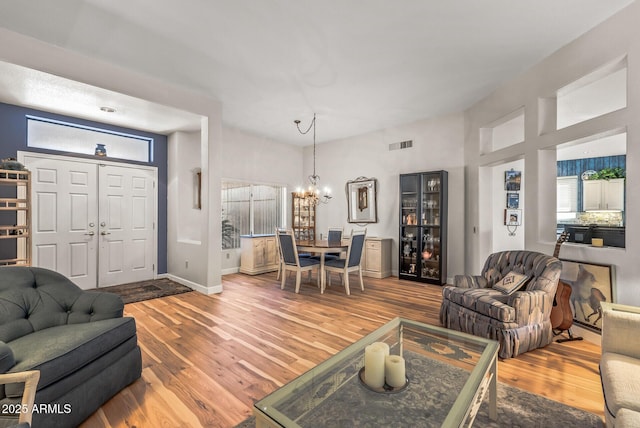 living room featuring an inviting chandelier, hardwood / wood-style floors, and wine cooler