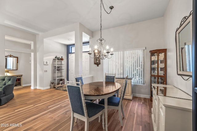 dining space featuring hardwood / wood-style floors and an inviting chandelier