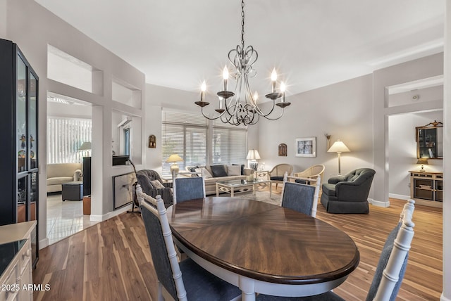 dining space with hardwood / wood-style flooring and a notable chandelier