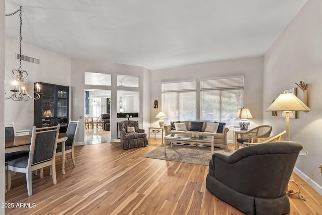 living room featuring an inviting chandelier and wood-type flooring