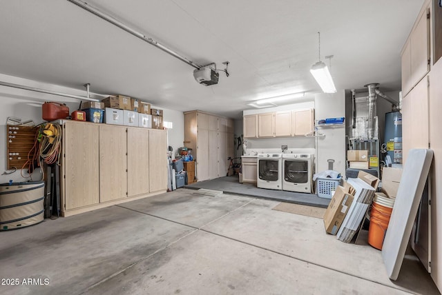 garage with a garage door opener, gas water heater, and washing machine and clothes dryer