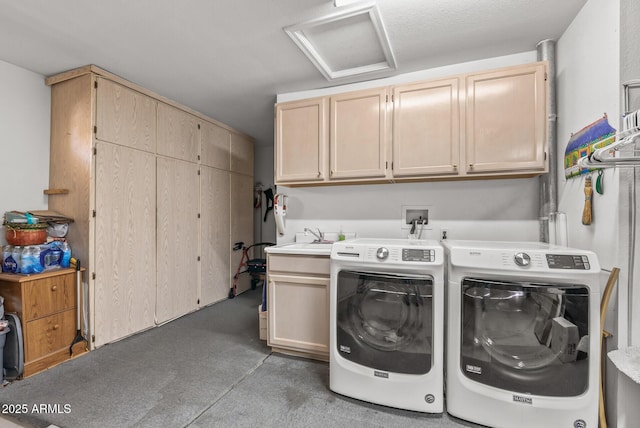 laundry area with cabinets, washing machine and dryer, and sink