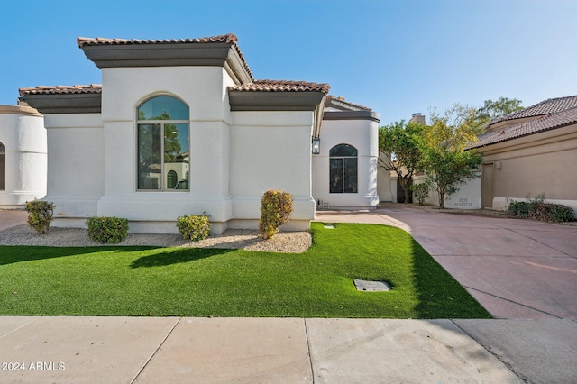 mediterranean / spanish-style house with a front yard