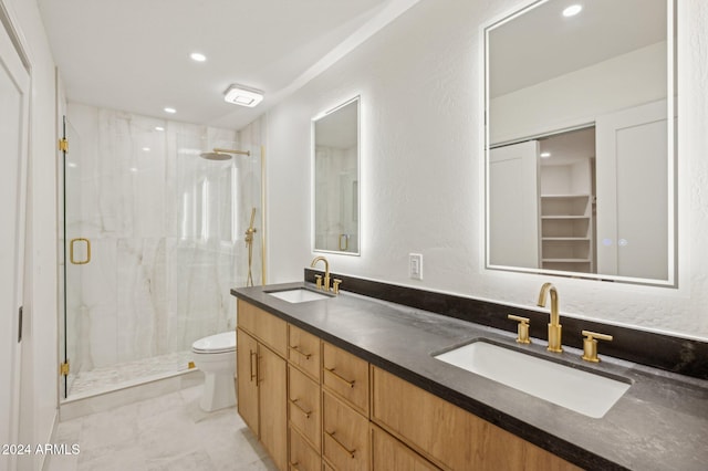 bathroom with a shower with door, vanity, and toilet