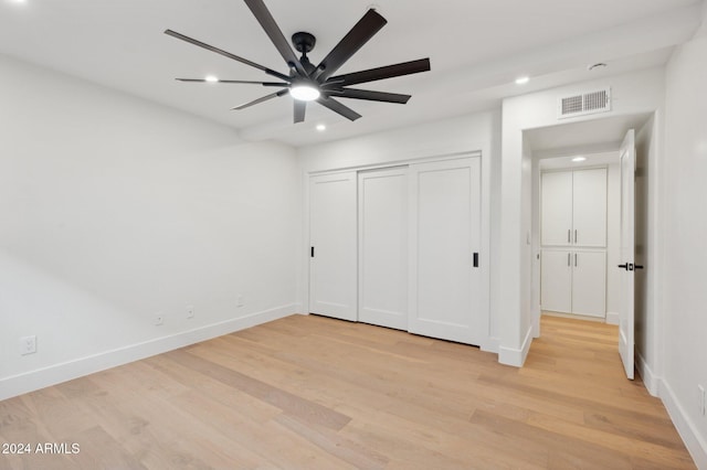 unfurnished bedroom with ceiling fan, a closet, and light hardwood / wood-style floors