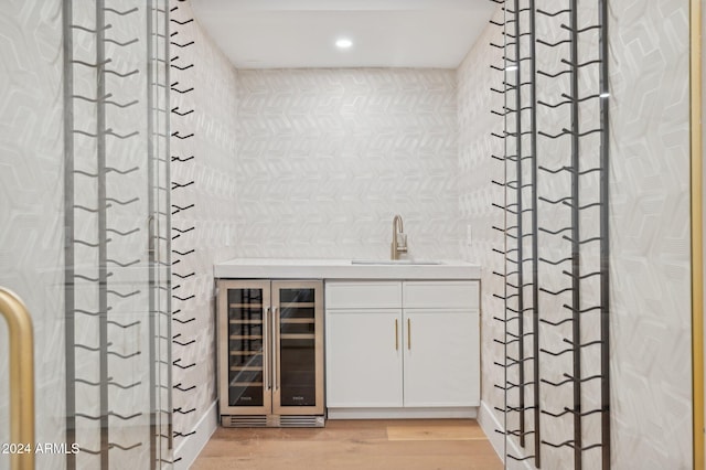 interior space featuring wine cooler, vanity, and hardwood / wood-style flooring