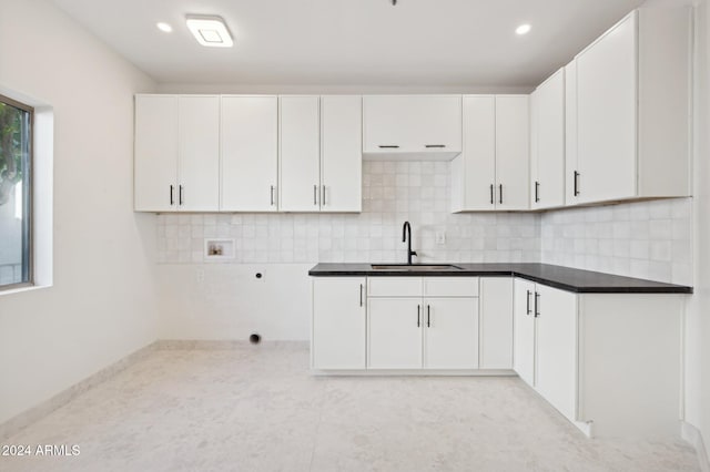 kitchen with tasteful backsplash, sink, and white cabinets