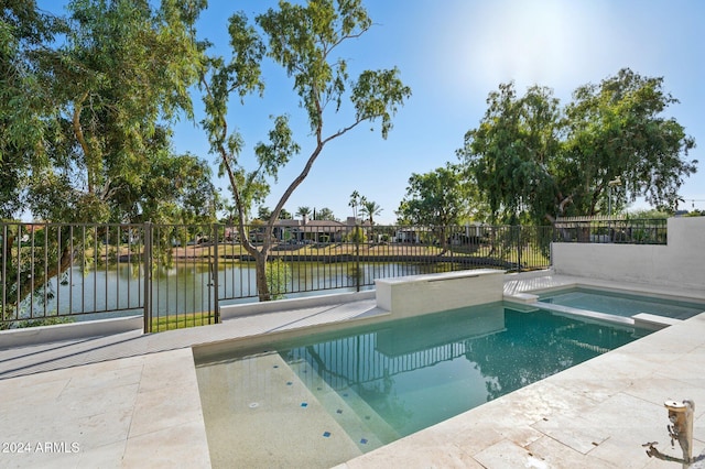 view of swimming pool with an in ground hot tub and a water view