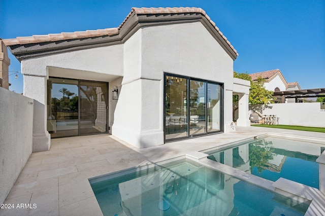 rear view of house featuring a fenced in pool and a patio