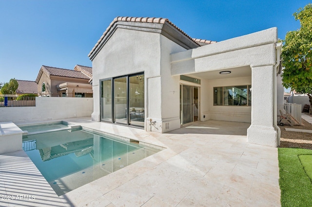 back of property with a patio and a fenced in pool