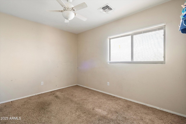 empty room with baseboards, visible vents, carpet floors, and ceiling fan