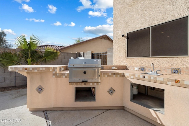 view of patio with a sink, grilling area, exterior kitchen, and fence