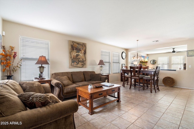 living room featuring light tile patterned floors, visible vents, and a notable chandelier