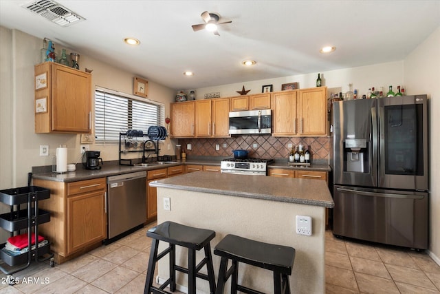 kitchen with visible vents, backsplash, light tile patterned floors, appliances with stainless steel finishes, and a sink