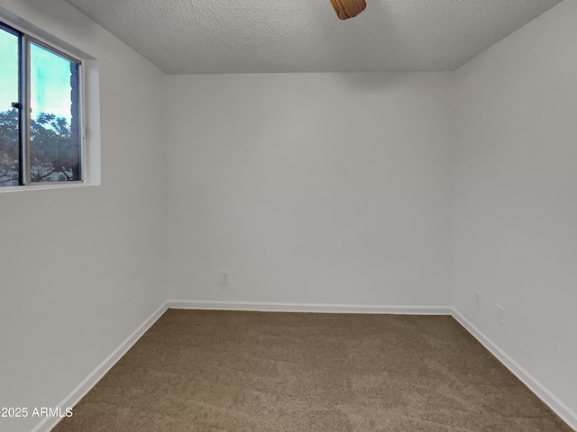 carpeted spare room featuring ceiling fan and a textured ceiling