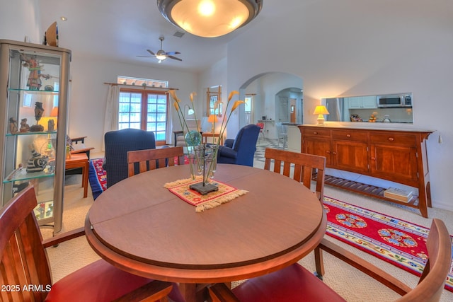 dining room featuring visible vents, a ceiling fan, and arched walkways