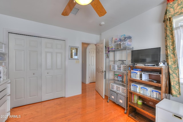 living area featuring a ceiling fan, visible vents, and light wood finished floors