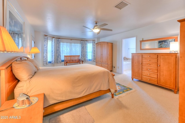 bedroom with ceiling fan, connected bathroom, visible vents, and light carpet