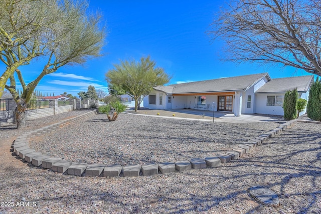 back of property featuring fence and stucco siding