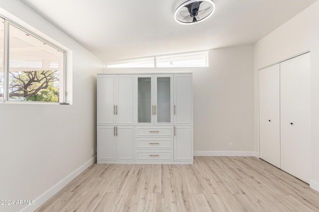 unfurnished bedroom featuring light wood-type flooring and vaulted ceiling