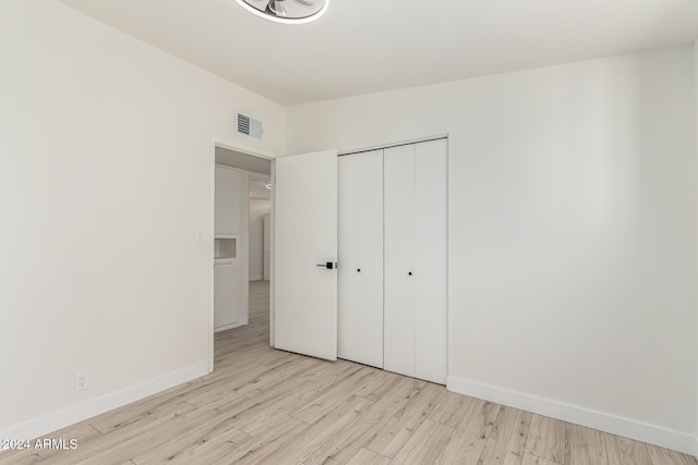 unfurnished bedroom featuring light hardwood / wood-style floors and a closet