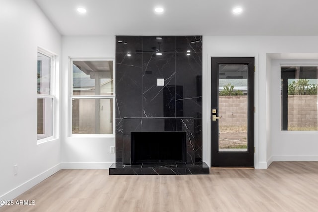 interior space with recessed lighting, wood finished floors, baseboards, and a premium fireplace