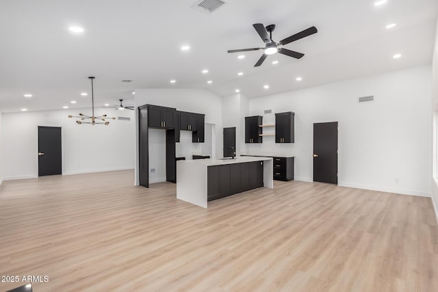 kitchen with open floor plan, ceiling fan, visible vents, and a kitchen island with sink