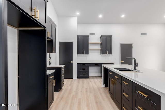 kitchen featuring open shelves, light countertops, visible vents, and a sink