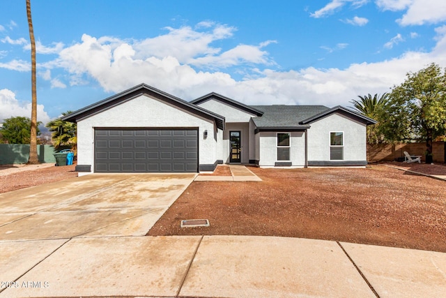 ranch-style home with stucco siding, a garage, concrete driveway, and fence