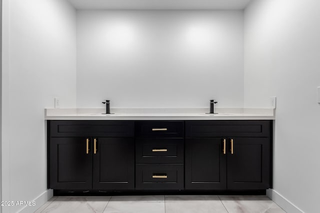 full bath featuring a sink, baseboards, and marble finish floor