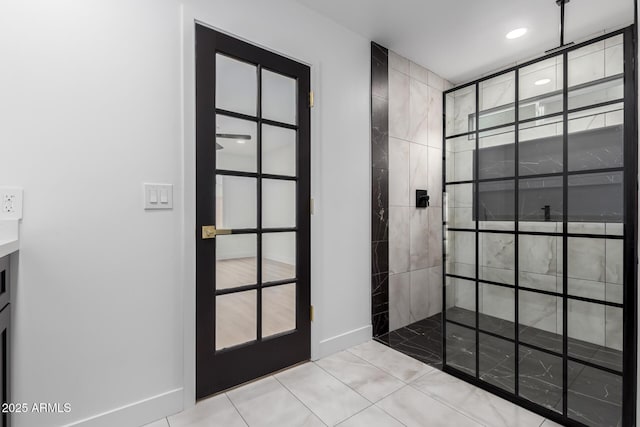 bathroom featuring tile patterned floors, baseboards, and walk in shower